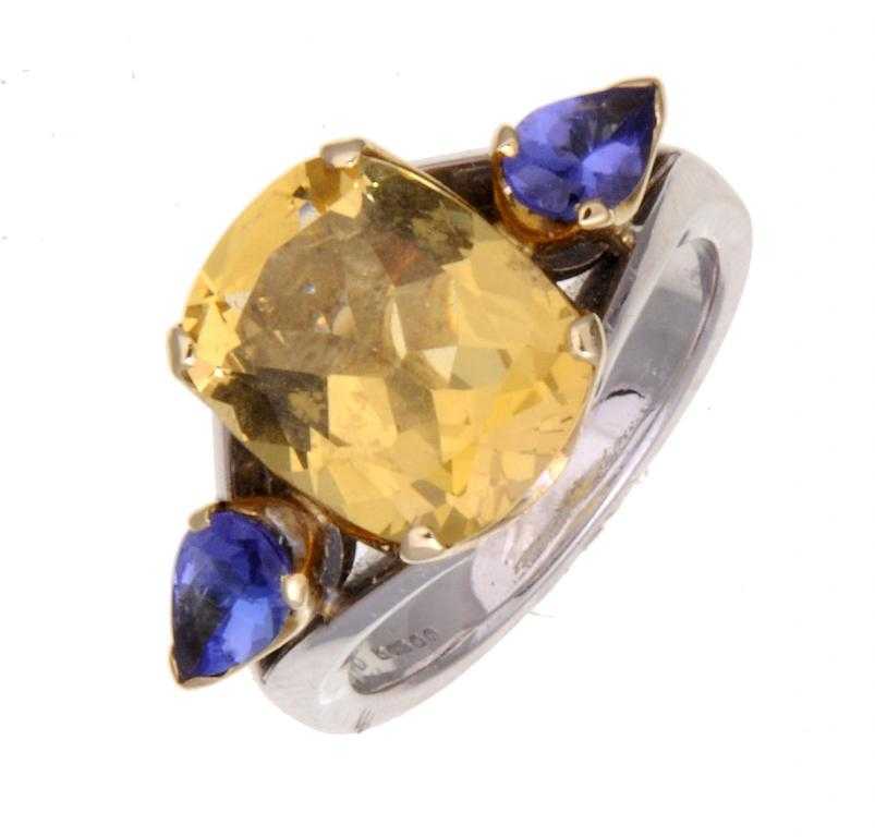 Appraisal: A SAPPHIRE RING the larger cushion shaped yellow sapphire flanked