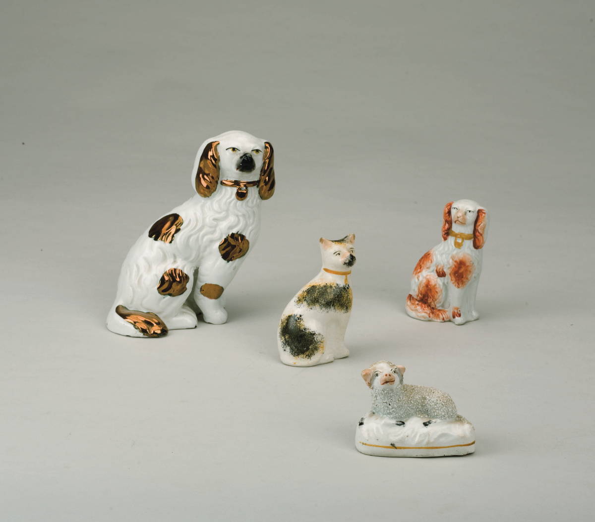 Appraisal: FOUR STAFFORDSHIRE ENAMEL OR LUSTRE-DECORATED FIGURES OF ANIMALS NINETEENTH-EARLY TWENTIETH