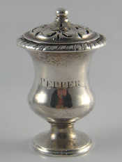 Appraisal: A silver pepper with gadrooned rim waisted cylindrical body on