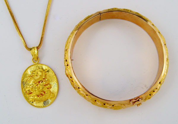 Appraisal: GOLD DRAGON MOTIF BANGLE BRACELET AND PENDANT Puffed bangle bracelet