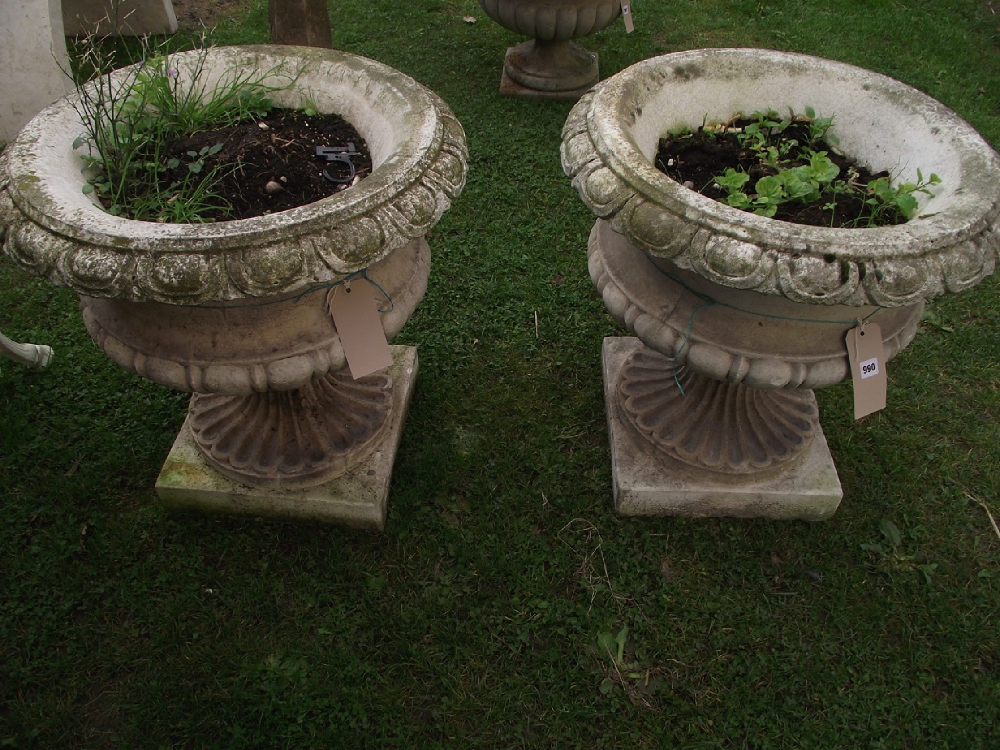 Appraisal: A pair of cast composition stone garden urns the squat