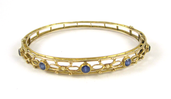 Appraisal: SAPPHIRE AND FOURTEEN KARAT GOLD BANGLE The yellow gold oval