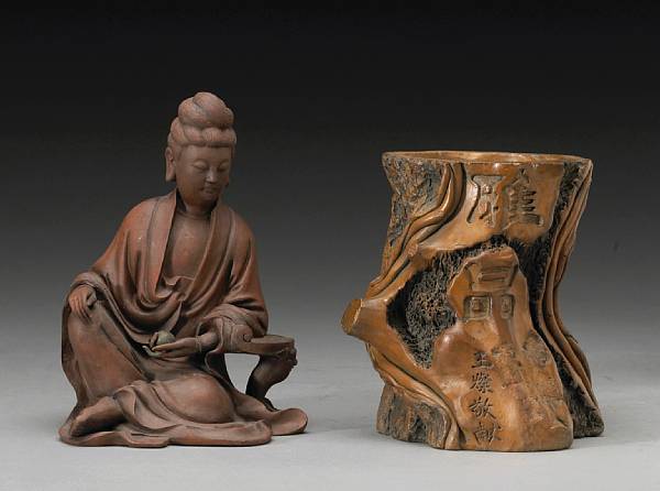 Appraisal: Two molded pottery decorations The first a seated Guanyin of