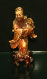 Appraisal: A Chinese carved hard stone figure of a Deity carrying