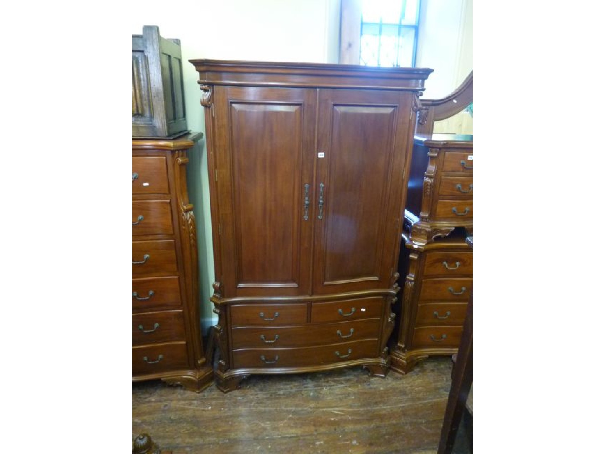 Appraisal: A mahogany freestanding linen press the lower section enclosed by