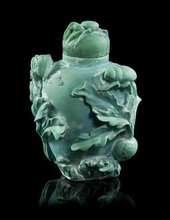 Appraisal: A Carved Turquoise Snuff Bottle having lotus blossoms beetles and