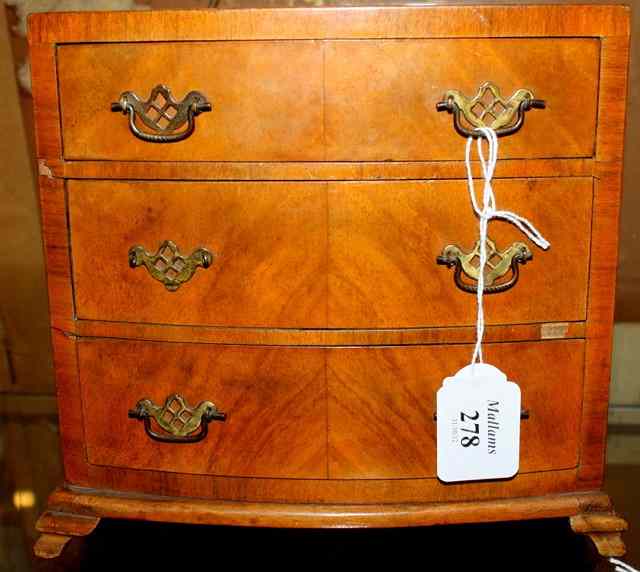 Appraisal: A MINIATURE WALNUT CHEST OF DRAWERS of bow fronted outline