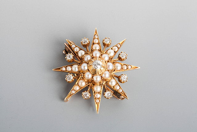 Appraisal: AN EDWARDIAN PEARL AND DIAMOND SET STAR BROOCH nine claw