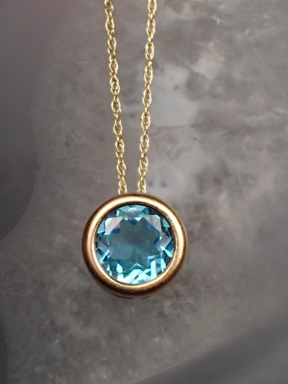 Appraisal: BLUE TOPAZ AND FOURTEEN KARAT GOLD PENDANT NECKLACE with an