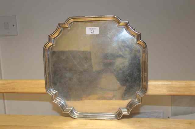 Appraisal: A SQUARE SILVER SALVER with shaped corners standing on short