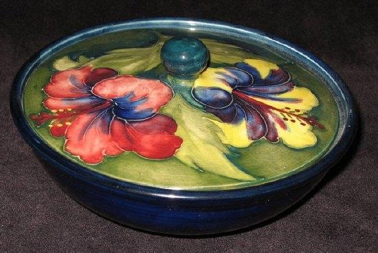 Appraisal: A Moorcroft circular lidded bowl 'Hibiscus' pattern on blue green