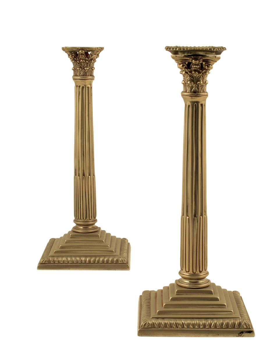 Appraisal: A pair of th century silvered metal Corinthian capital candlesticks