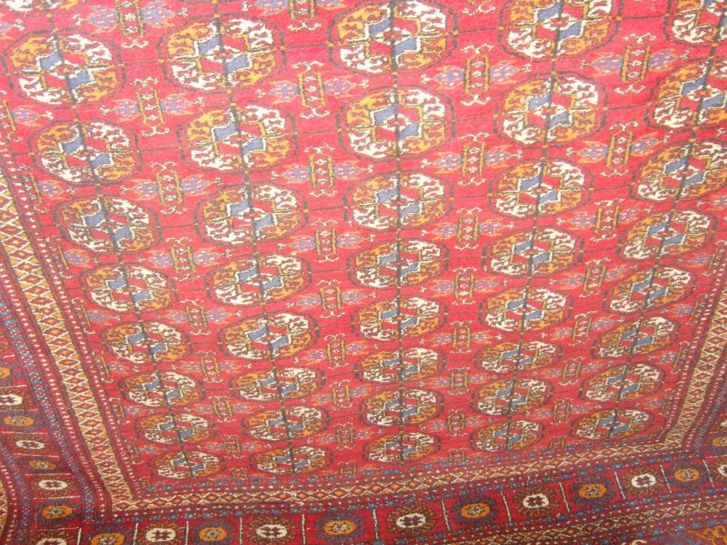 Appraisal: A red ground eastern wool carpet with repeating gul motifs