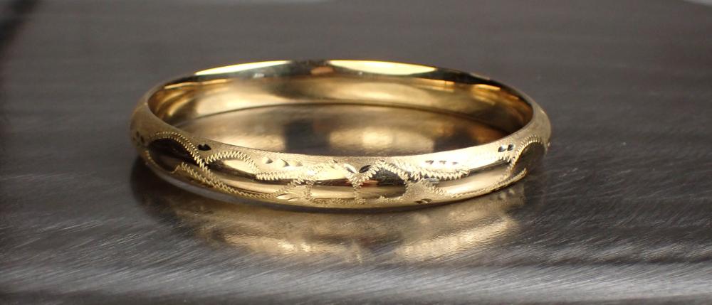 Appraisal: ETCHED FOURTEEN KARAT YELLOW GOLD BANGLE BRACELET The oval hinged