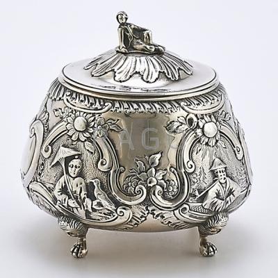 Appraisal: GEORGE III SILVER REPOUSSE CHINOISERIE TEA CADDY Round form on