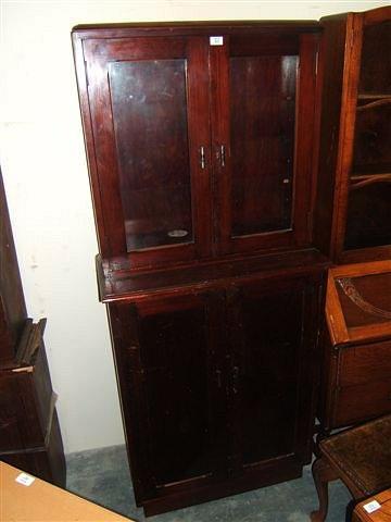 Appraisal: A mahogany cupboard with glazed doors above and panelled doors