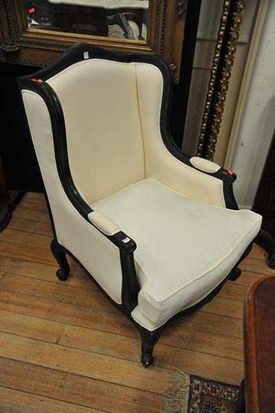 Appraisal: A BERGERE UPHOLSTERED IN WHITE CALICO WITH BLACK PAINTED FRAME