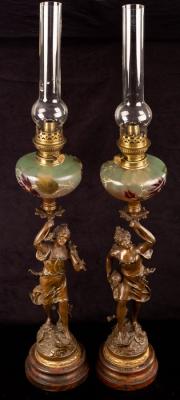 Appraisal: A pair of figural spelter oil lamps with coloured glass