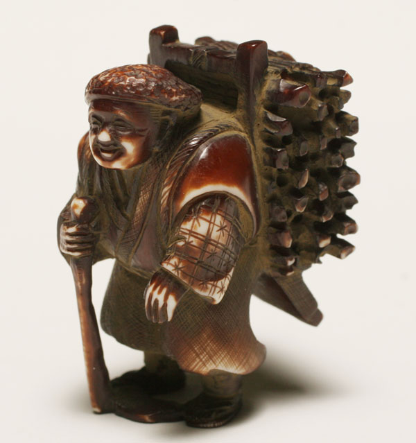 Appraisal: Japanese dyed ivory netsuke figure with bundle of firewood stooped