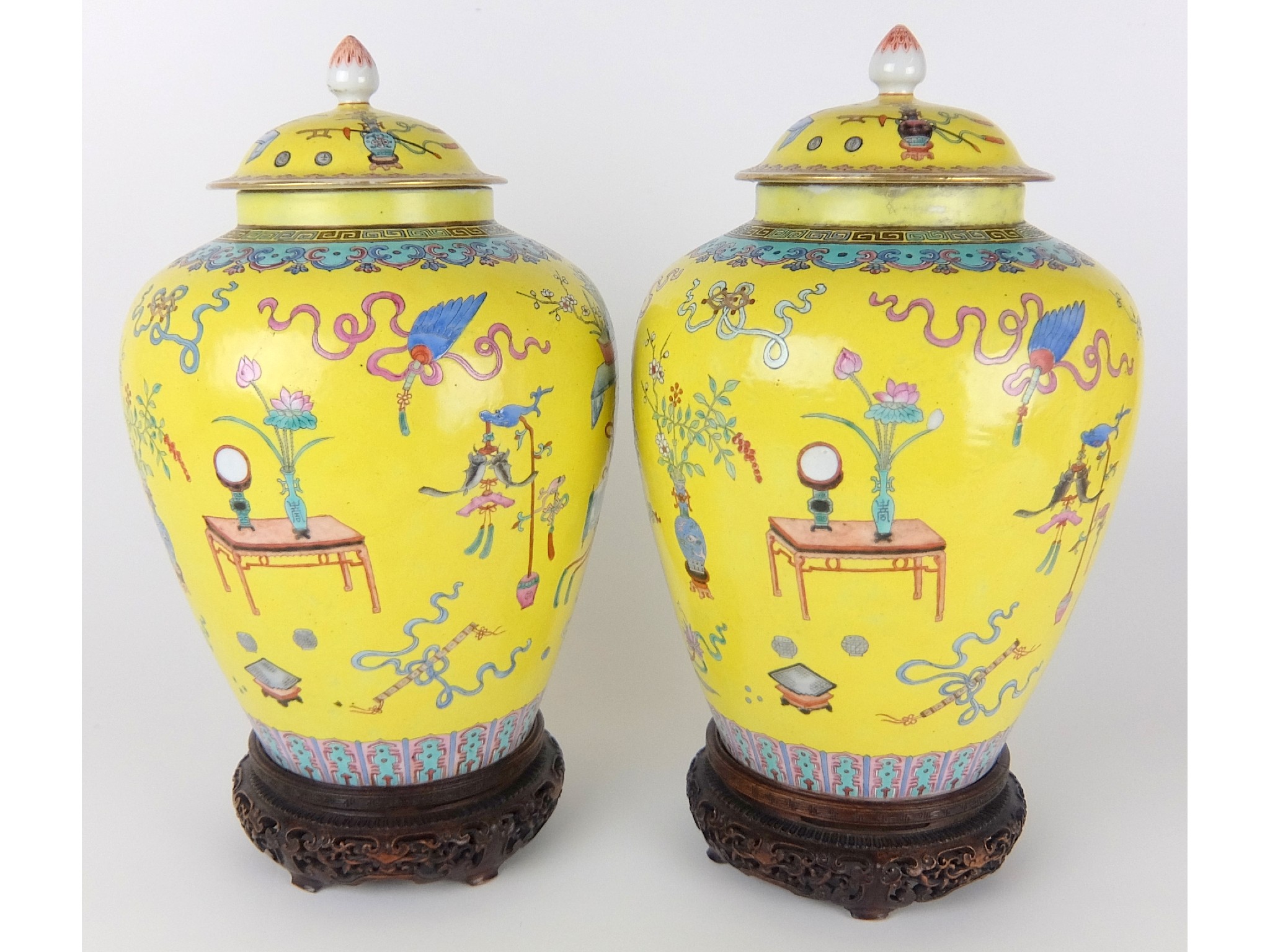 Appraisal: A pair of famille jaune baluster vasesand domed covers painted