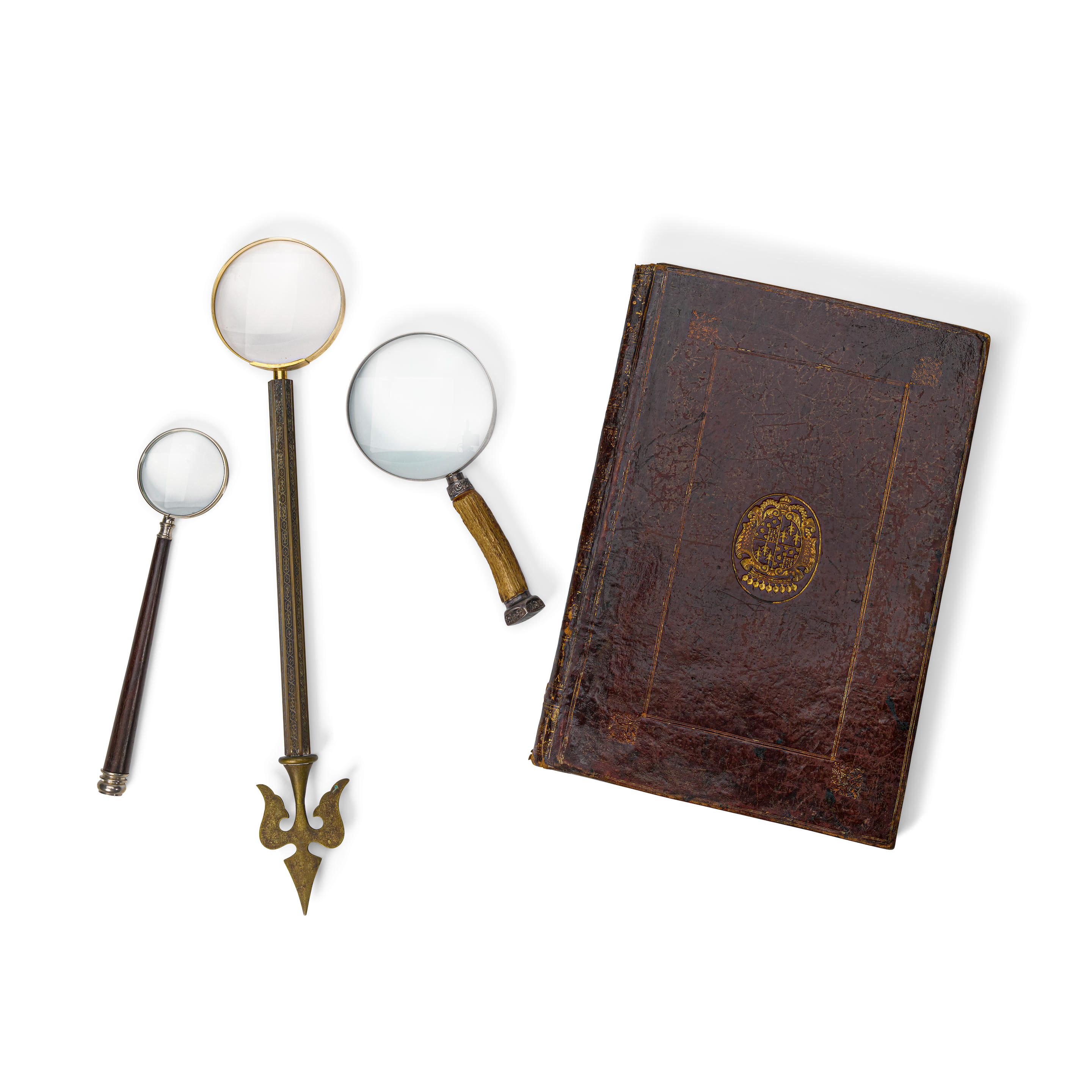 Appraisal: A GROUP OF THREE MAGNIFYING GLASSES Together with a red