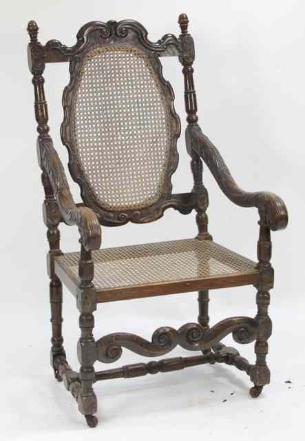 Appraisal: A Jacobean style walnut cane back armchair with scroll carved