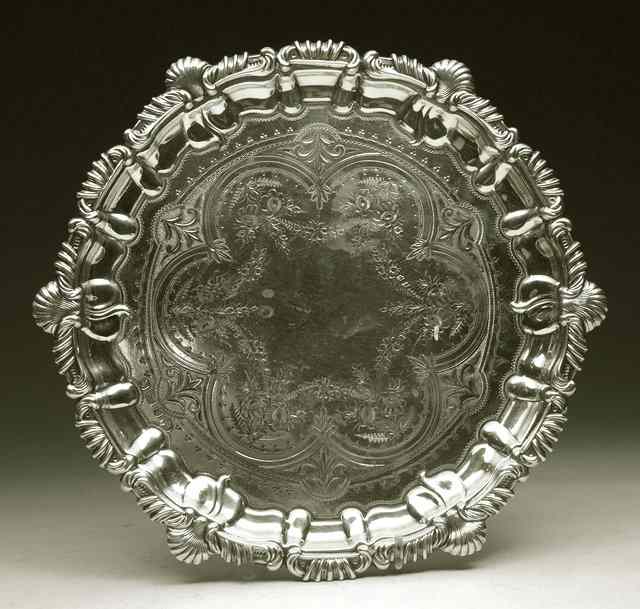 Appraisal: AN EDWARDIAN SILVER SALVER with shell and scroll border and