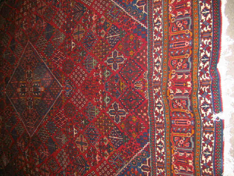 Appraisal: JOSHAQAN ROOM RUG The red field of floral diamond motifs