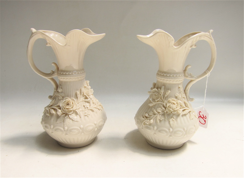 Appraisal: PAIR BELLEEK ABERDEEN PORCELAIN EWERS with applied flowers in opposing