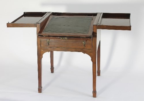 Appraisal: A mahogany writing table the hinged two-flap top enclosing a