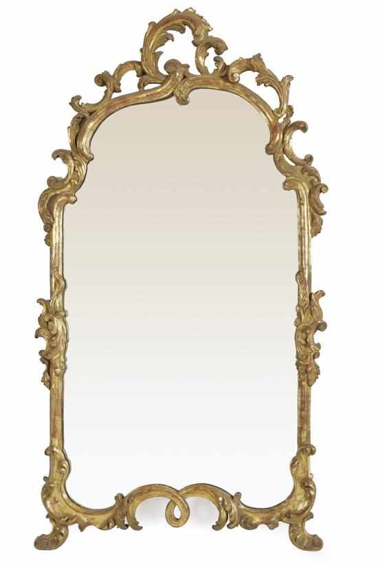 Appraisal: A CHIPPENDALE STYLE GILTWOOD WALL MIRROR The shaped rectangular plate