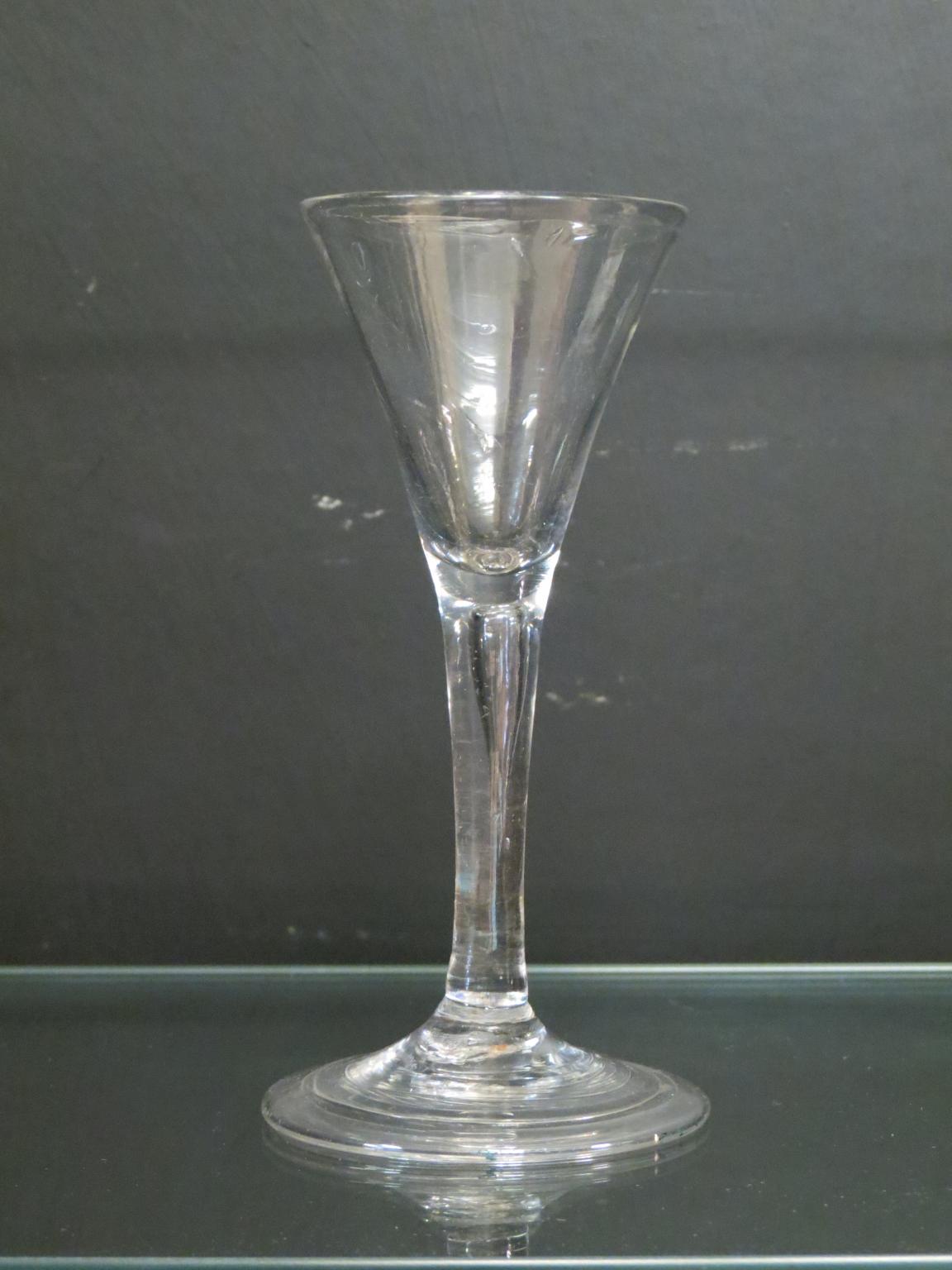 Appraisal: An th century English cordial glass drawn-trumpet form with single