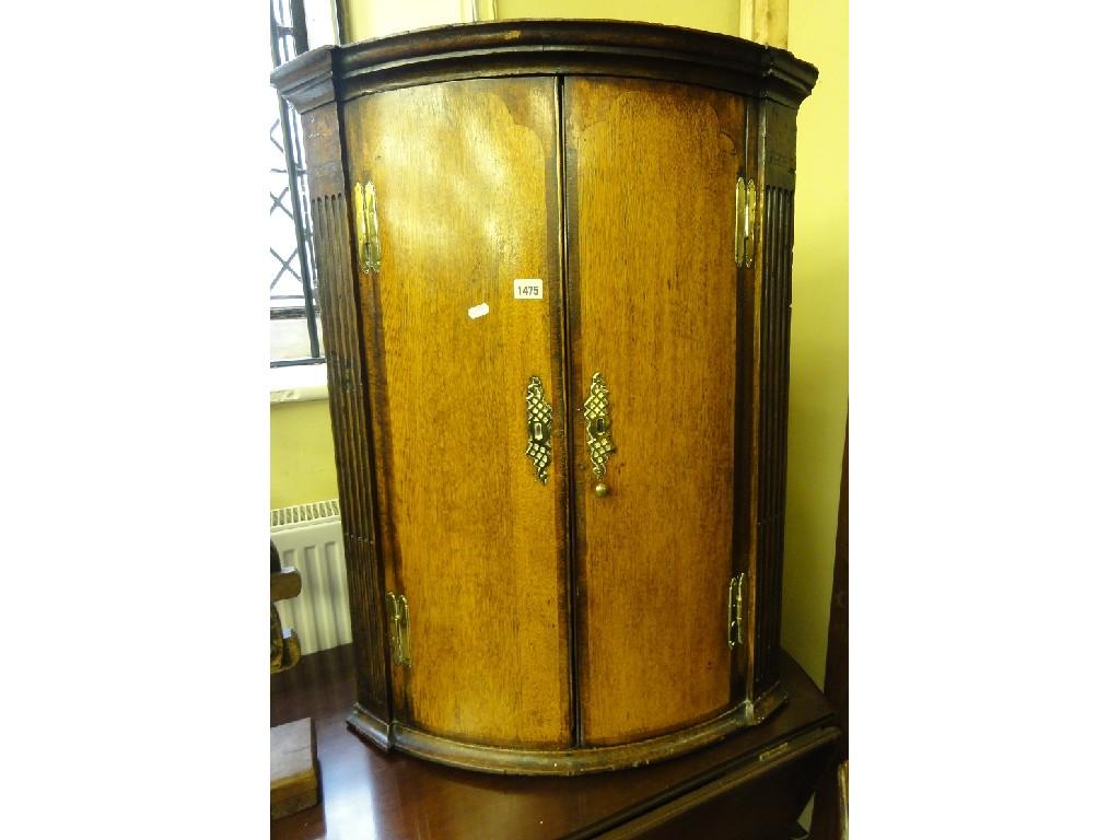 Appraisal: A Georgian oak hanging corner cupboard with stepped and moulded