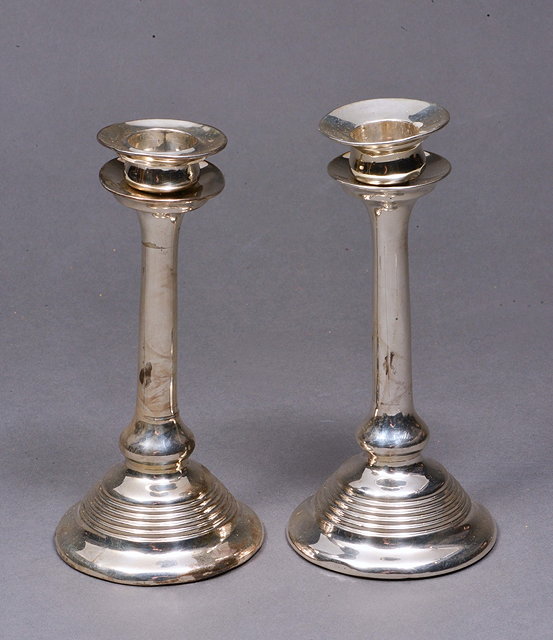 Appraisal: A PAIR OF TURNED SILVER CANDLESTICKS on stepped feet and