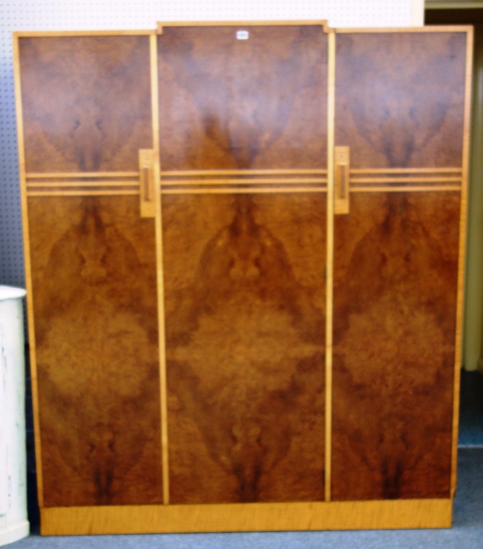 Appraisal: An Art Deco figured walnut satinwood banded three door wardrobe