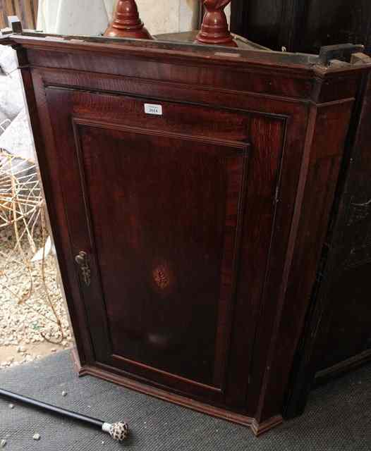 Appraisal: A GEORGIAN OAK HANGING CORNER CUPBOARD the single panelled door