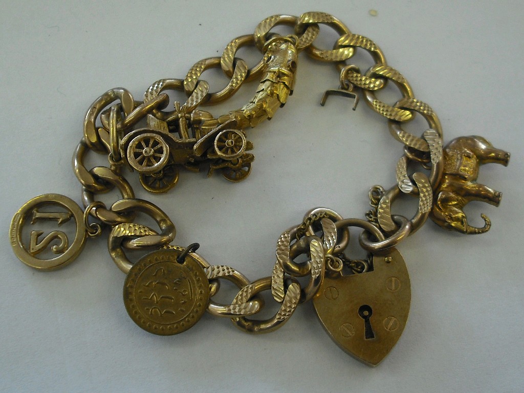 Appraisal: ct curb link charm bracelet with five charms and padlock