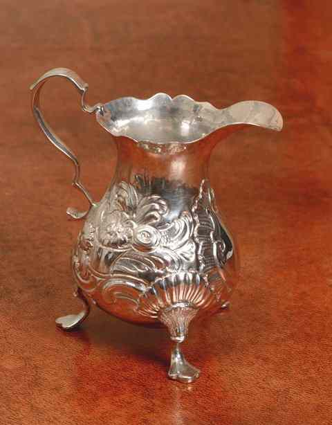 Appraisal: A GEORGE II SILVER HELMET SHAPED CREAM JUG chased with