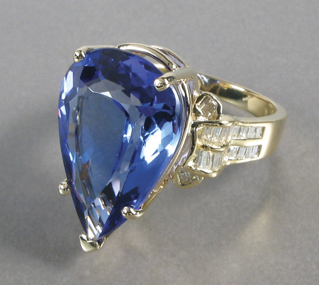 Appraisal: TANZANITE AND DIAMOND RING k yellow gold centering a pear-cut