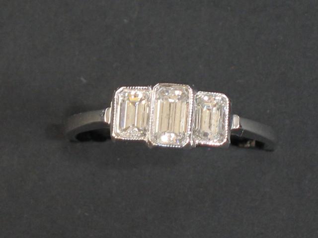 Appraisal: A THREE STONE DIAMOND RING the central baguette-cut diamond flanked