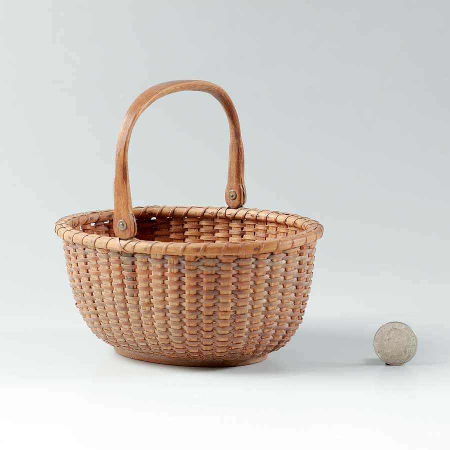 Appraisal: DIMINUTIVE NANTUCKET SWING HANDLE BASKET Oval woven basket swing handle