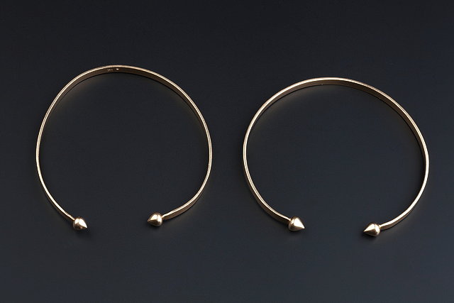 Appraisal: A PAIR OF TORQUE BANGLES with heart-shaped terminals stamped '