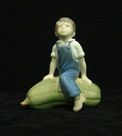 Appraisal: A Royal Copenhagen figure of a young boy seated upon