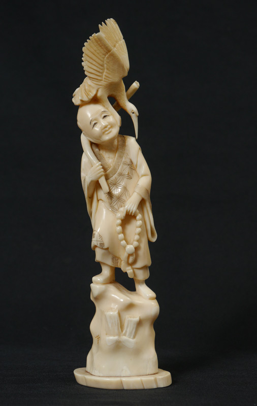 Appraisal: CARVED IVORY FIGURAL GROUP MAN WITH CRANE Figure of a