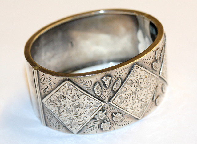 Appraisal: A LATE VICTORIAN SILVER HINGED BANGLE with applied leaf decorated