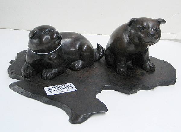 Appraisal: Two cast bronze puppies The pair of young dogs both