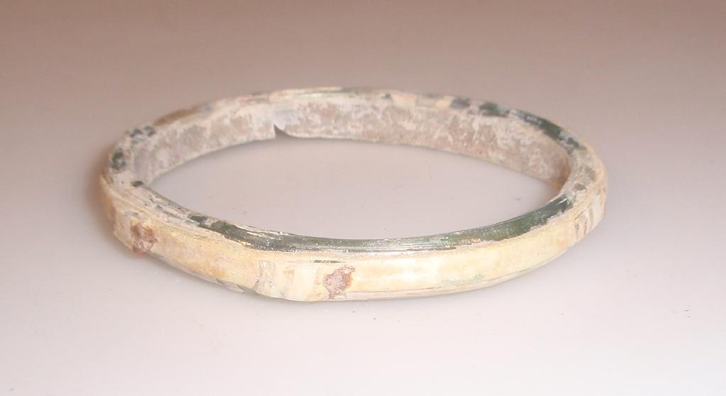 Appraisal: An Islamic pale green glass bangle decorated with a central