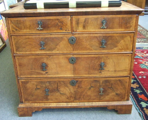 Appraisal: An th century walnut chest with feather banded top over