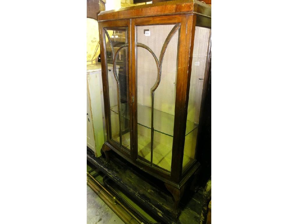 Appraisal: A walnut veneered bow fronted china display cabinet enclosed by