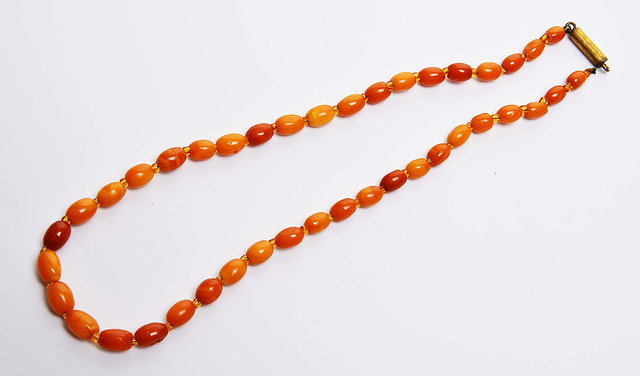 Appraisal: A BUTTERSCOTCH AMBER BEAD NECKLACE each bead of oval form